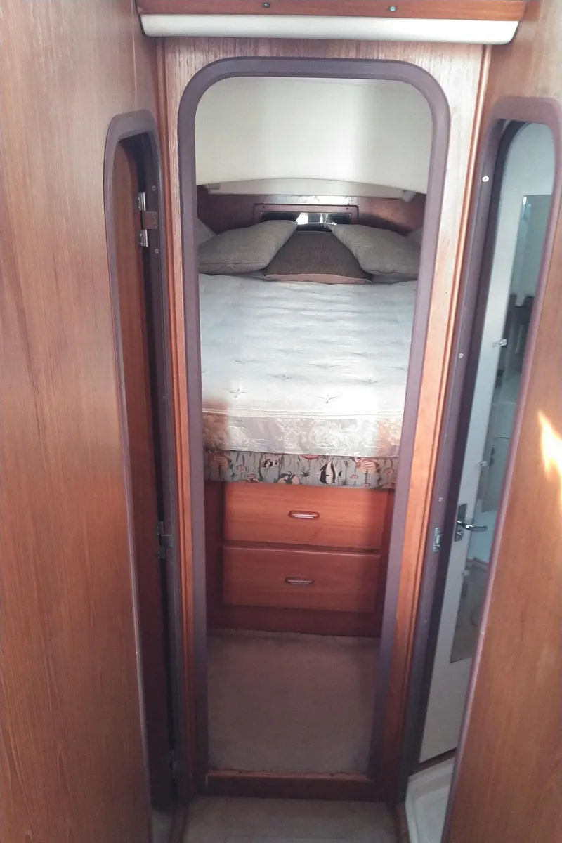 Slide: The Image of 1999 Mainship 350 Trawler cabin interior with bed and storage drawers. - 33