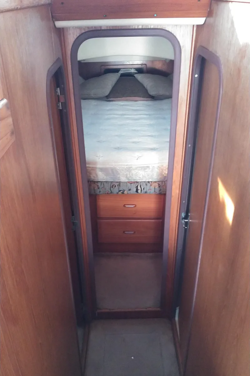 Slide: The Image of 1999 Mainship 350 Trawler interior cabin with bed and storage drawers. - 34
