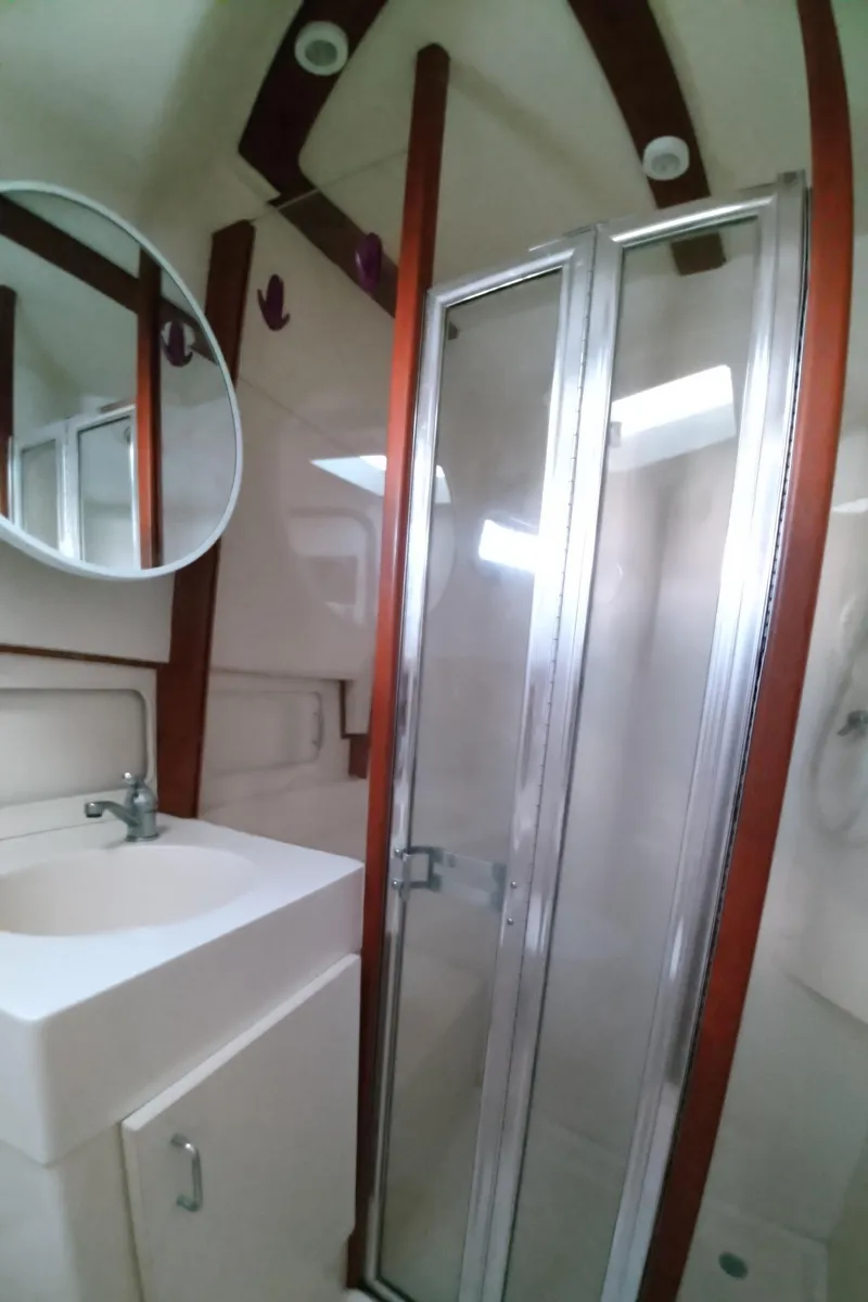 Slide: The Image of Bathroom of 1999 Mainship 350 Trawler with shower, sink, and mirror. - 39
