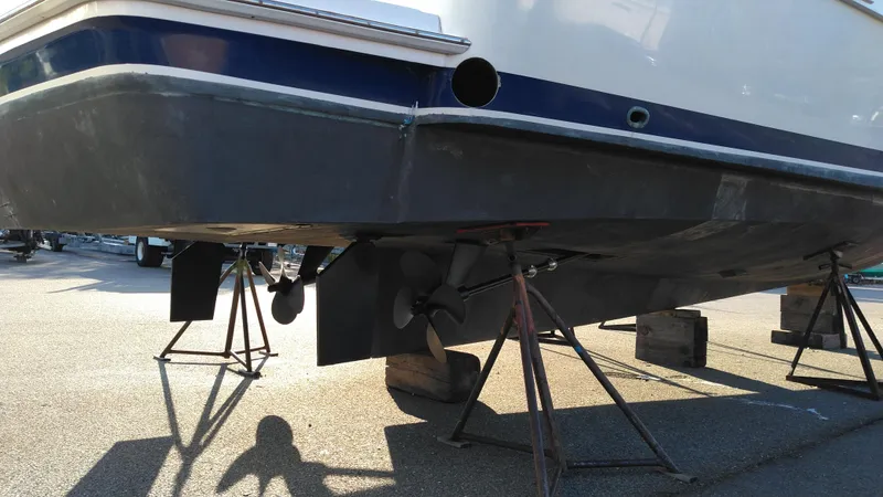 Slide: The Image of 1999 Mainship 350 Trawler on stands, showing propellers and hull. - 4