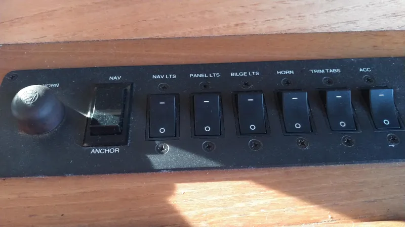 Slide: The Image of Control panel of a 1999 Mainship 350 Trawler with various switches. - 43