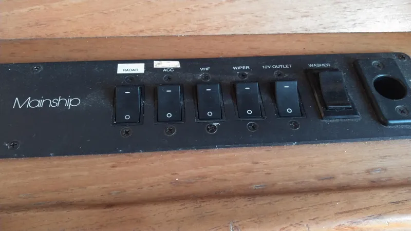 Slide: The Image of Control panel of a 1999 Mainship 350 Trawler with various switches. - 44