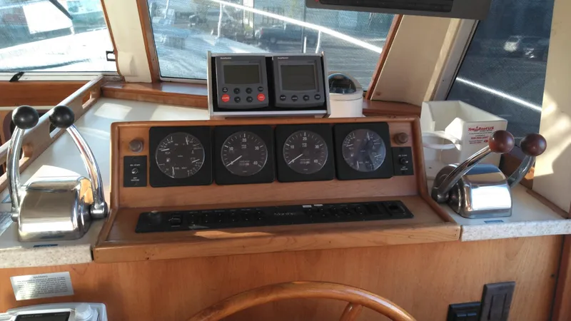 Slide: The Image of 1999 Mainship 350 Trawler helm with gauges, controls, and navigation instruments. - 45