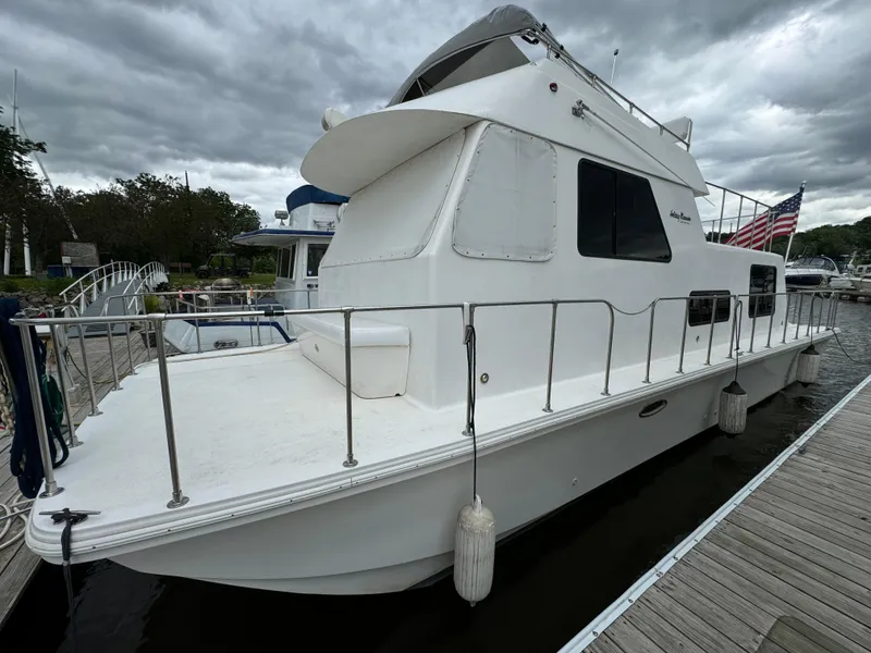 Slide: The Image of 2008 Holiday Mansion 37 houseboat docked, featuring white exterior and American flag. - 7