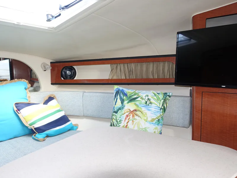 Slide: The Image of Interior of 2004 Sea Ray 280 Sundancer with colorful cushions and a mounted TV. - 13