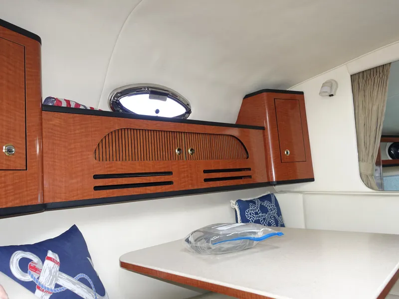 Slide: The Image of Interior of 2004 Sea Ray 280 Sundancer with wooden cabinets and dining area. - 18