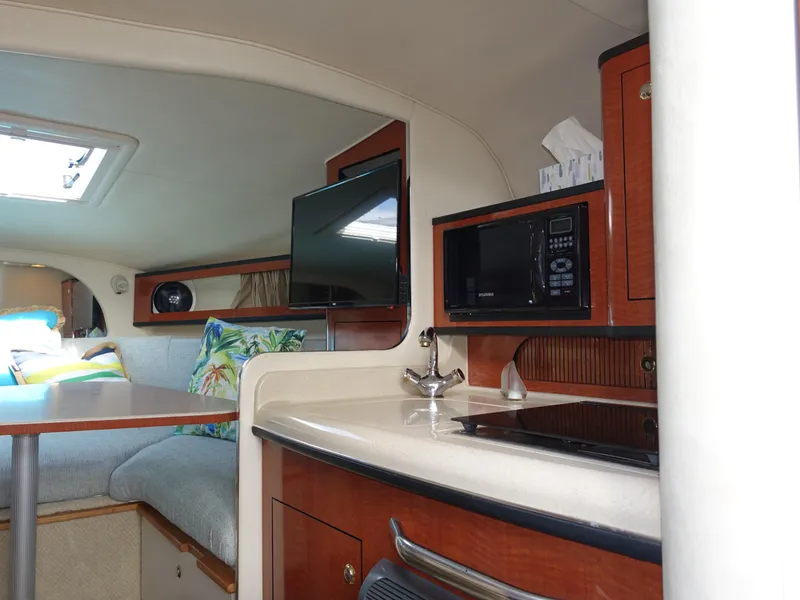 Slide: The Image of Interior of 2004 Sea Ray 280 Sundancer with kitchenette and seating area. - 19