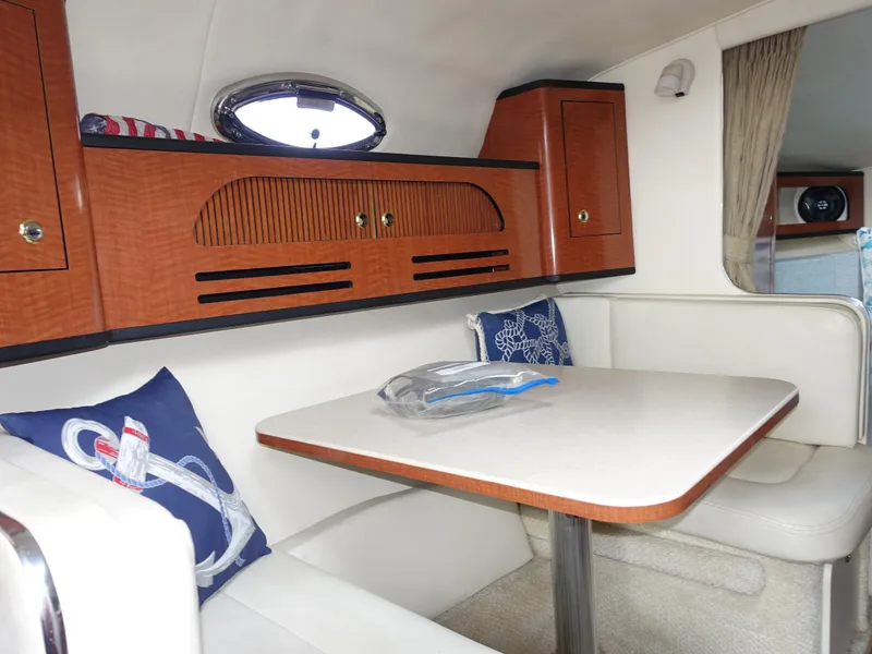 Slide: The Image of Interior of 2004 Sea Ray 280 Sundancer with dining area and wooden cabinetry. - 20