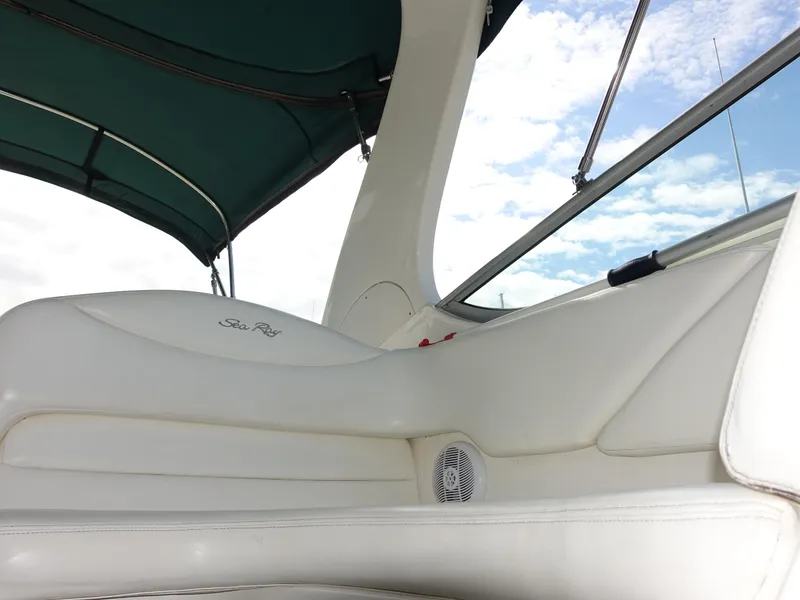 Slide: The Image of 2004 Sea Ray 280 Sundancer boat interior with white seating and green canopy. - 25