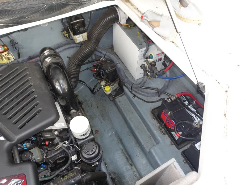 Slide: The Image of Engine compartment of 2004 Sea Ray 280 Sundancer boat, showing mechanical components and battery. - 29
