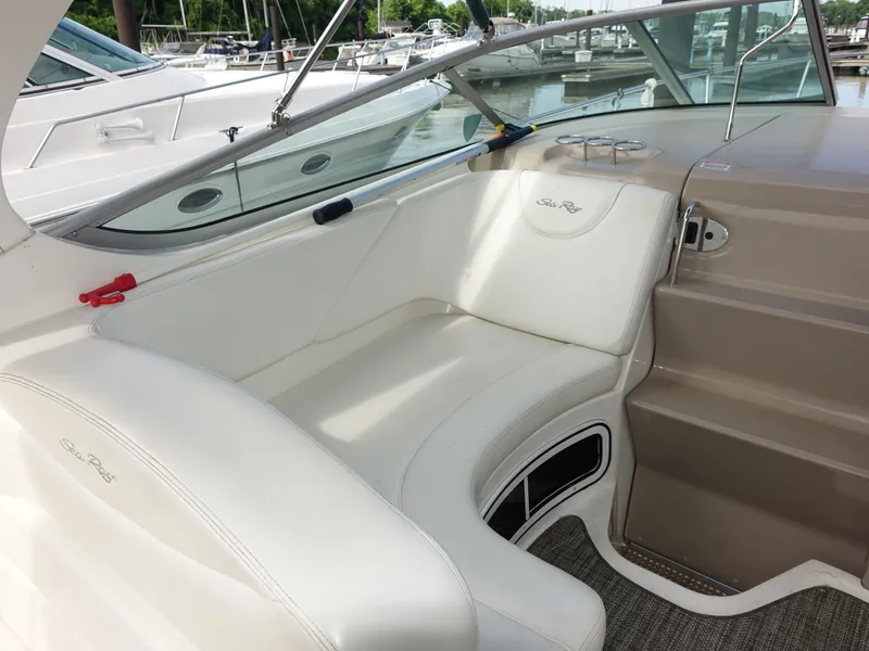 Slide: The Image of 2004 Sea Ray 280 Sundancer interior with white seating and marina view. - 5