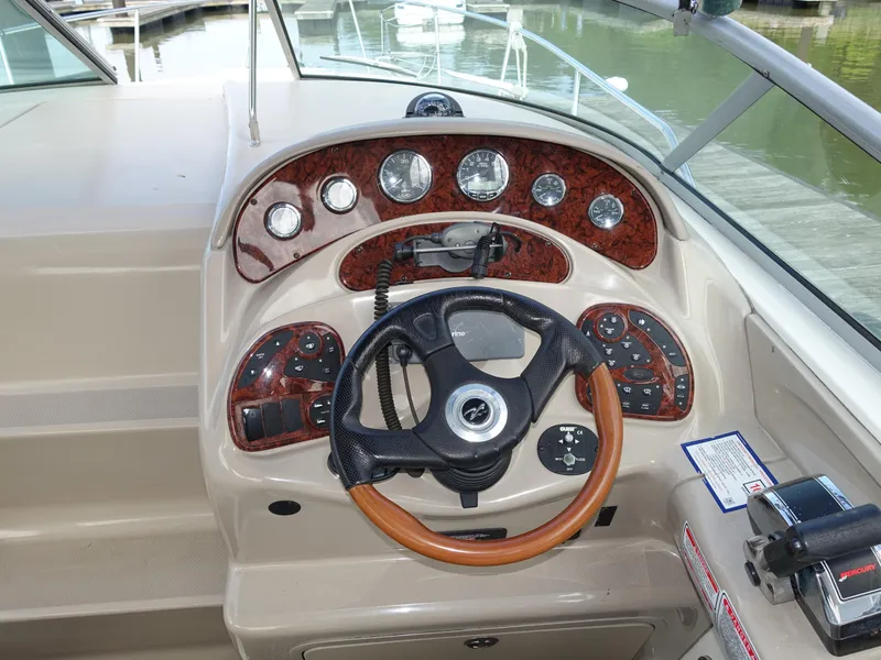 Slide: The Image of 2004 Sea Ray 280 Sundancer helm with wood accents and modern controls. - 6