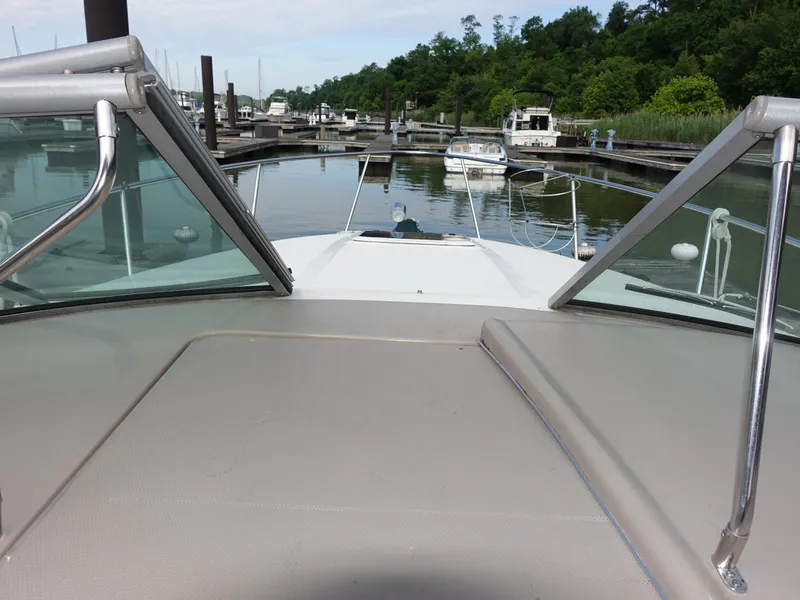 Slide: The Image of 2004 Sea Ray 280 Sundancer boat docked in a marina, surrounded by lush greenery. - 7