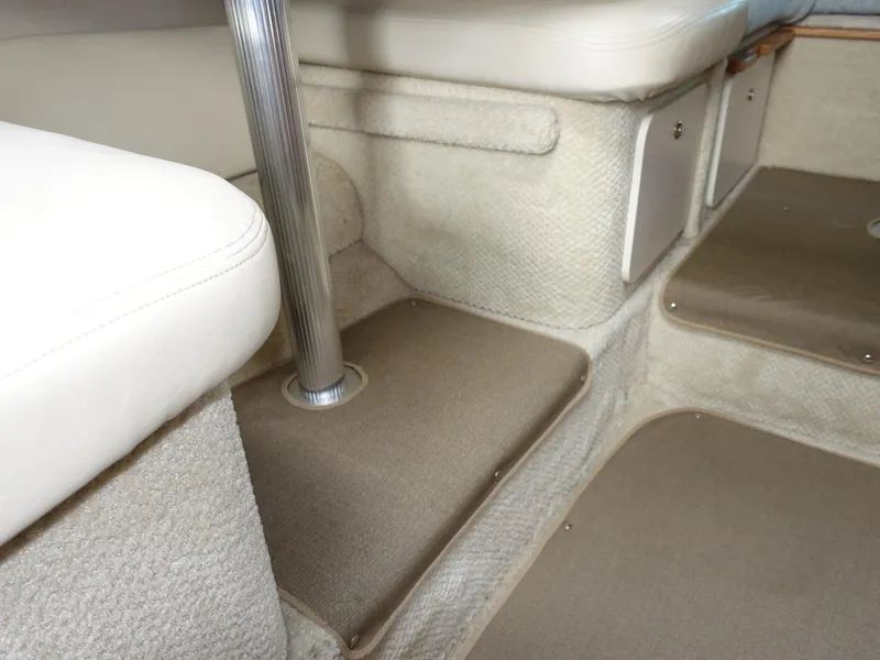 Slide: The Image of Interior of 2004 Sea Ray 280 Sundancer boat, featuring beige carpet and seating. - 9