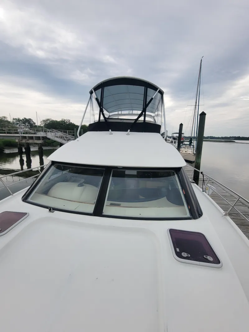 Slide: The Image of 2003 Lion Robertson & Caine Lion 46 yacht docked by a serene waterfront. - 10