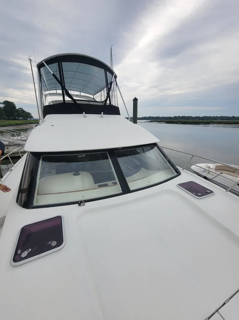 Slide: The Image of 2003 Robertson & Caine Lion 46 yacht docked by a serene waterfront. - 13