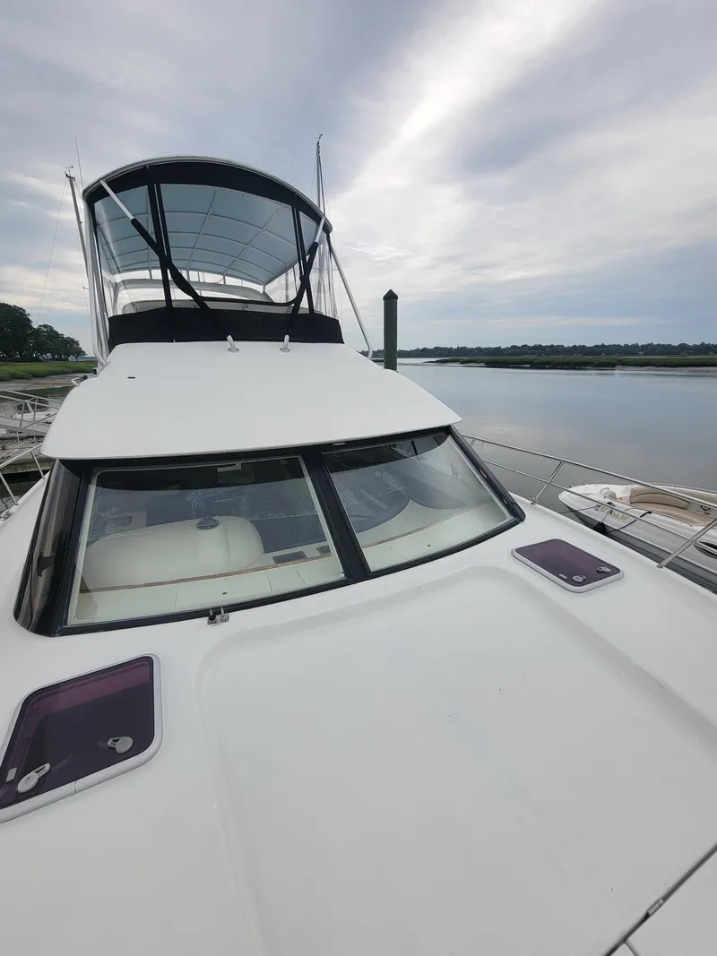 Slide: The Image of 2003 Robertson & Caine Lion 46 yacht docked by a serene waterfront. - 14