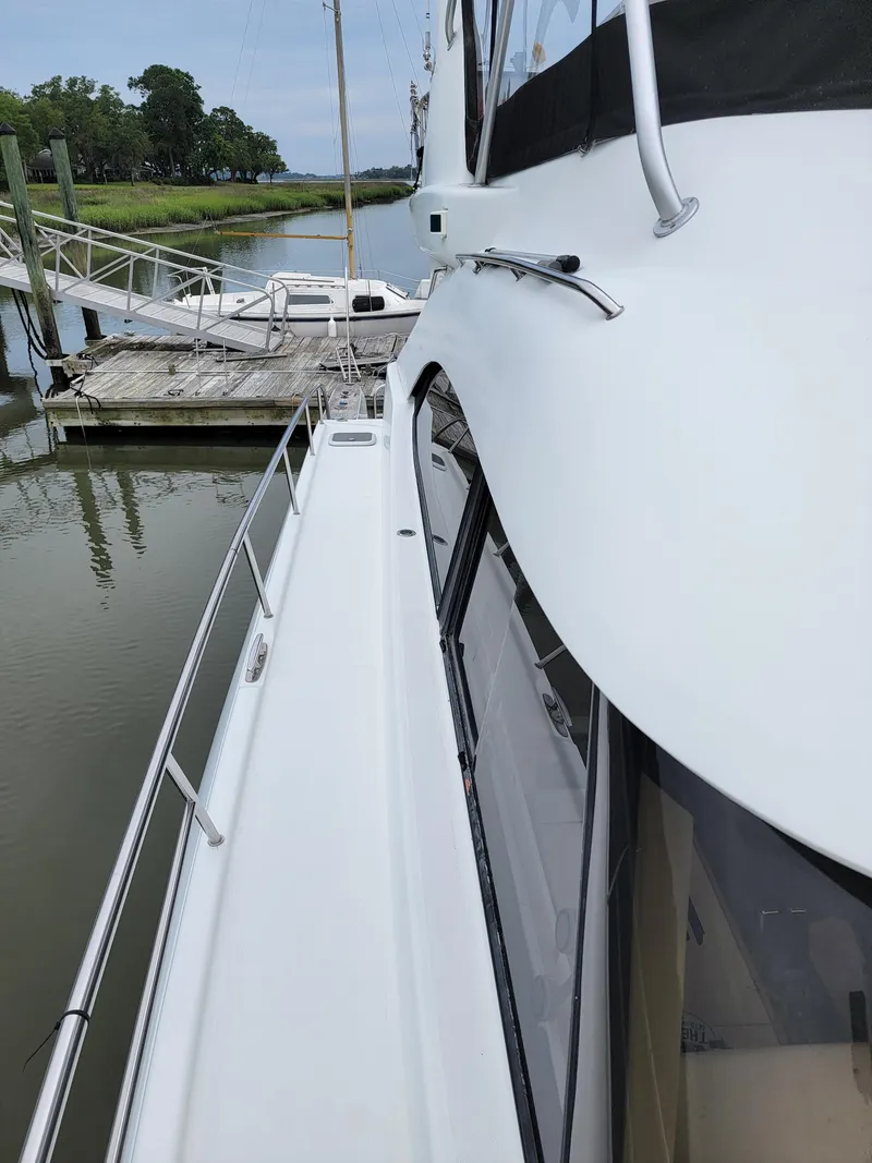 Slide: The Image of Side view of 2003 Robertson & Caine Lion 46 yacht docked by a pier. - 17
