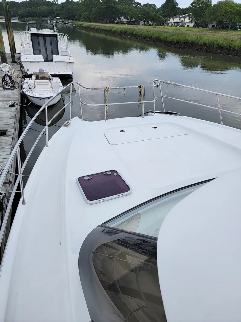 Slide: The Image of 2003 Lion Robertson & Caine Lion 46 yacht docked by a serene river. - 22