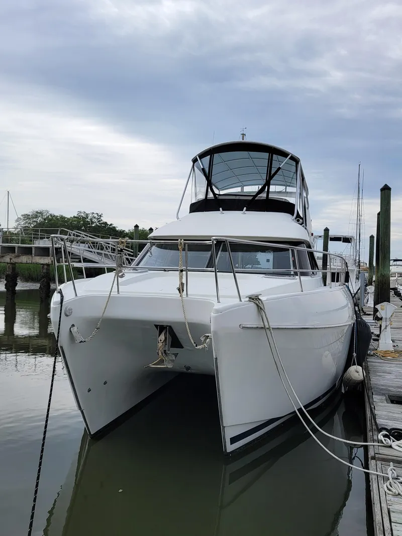 Slide: The Image of 2003 Robertson & Caine Lion 46 catamaran docked at marina under cloudy sky. - 3