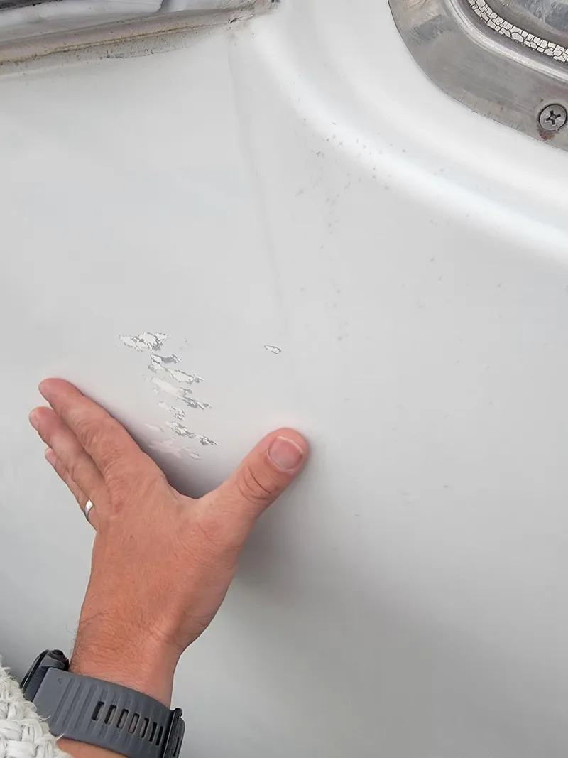 Slide: The Image of Hand inspecting damage on 2003 Robertson & Caine Lion 46 boat hull. - 48