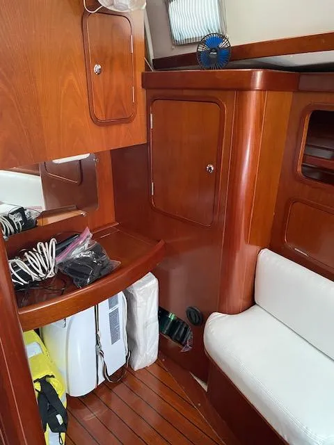 Slide: The Image of Interior of 2001 Beneteau Oceanis 44 CC sailboat with wooden cabinetry and white seating. - 10