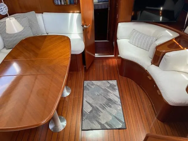 Slide: The Image of Interior of 2001 Beneteau Oceanis 44 CC yacht with wooden flooring and white seating. - 11