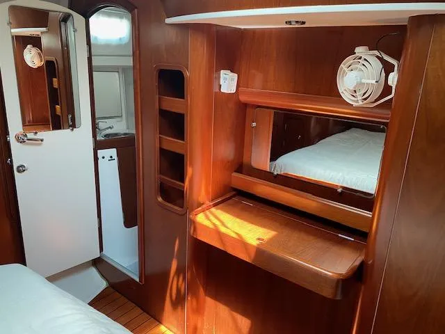 Slide: The Image of Interior of 2001 Beneteau Oceanis 44 CC yacht with wooden cabinetry and cozy sleeping area. - 16