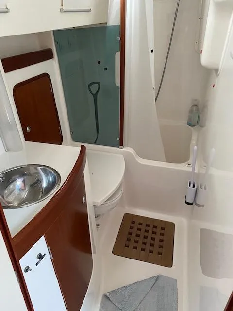 Slide: The Image of 2001 Beneteau Oceanis 44 CC yacht bathroom with sink, shower, and wooden accents. - 20