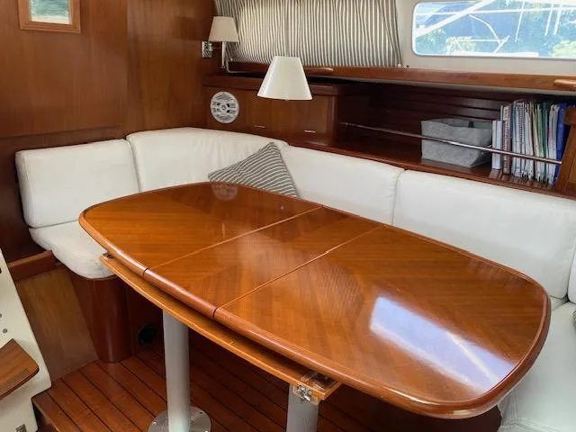Slide: The Image of Interior of 2001 Beneteau Oceanis 44 CC yacht with wooden table and white seating. - 9