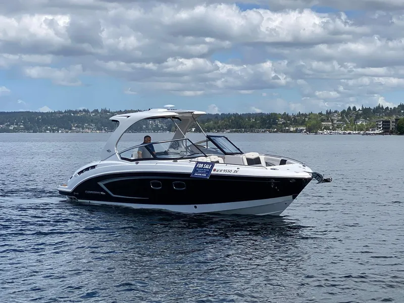 Slide: The Image of 2012 Chaparral 327 SSX boat on water, for sale sign visible, cloudy sky background. - 21