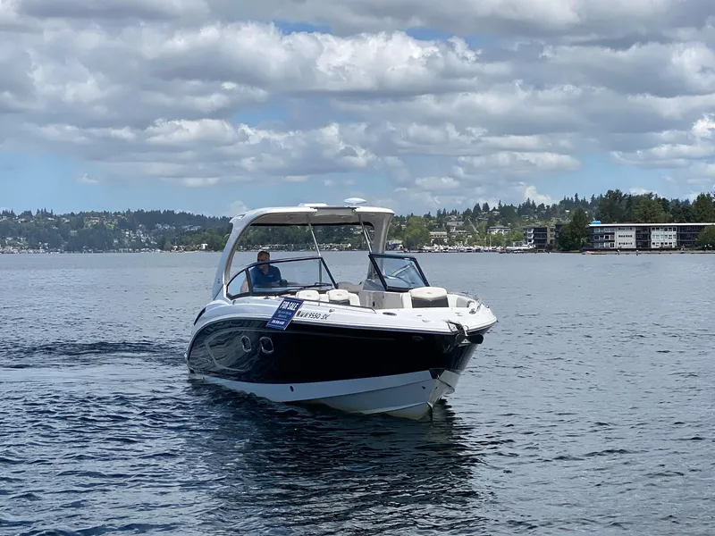 Slide: The Image of 2012 Chaparral 327 SSX boat cruising on a lake under cloudy skies. - 22