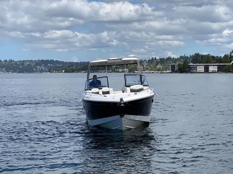 Slide: The Image of 2012 Chaparral 327 SSX boat cruising on a lake under a cloudy sky. - 23