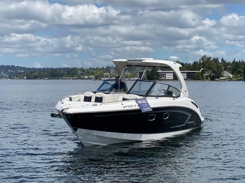 Slide: The Image of 2012 Chaparral 327 SSX boat on water, for sale sign visible, cloudy sky background. - 24