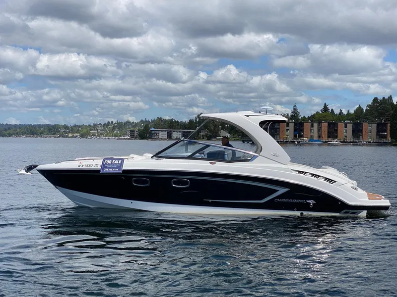 Slide: The Image of 2012 Chaparral 327 SSX boat on water, for sale sign visible, cloudy sky background. - 26