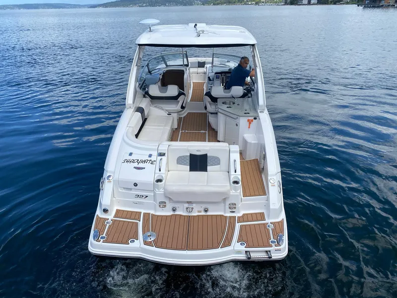 Slide: The Image of 2012 Chaparral 327 SSX boat cruising on a calm lake with a person at the helm. - 3
