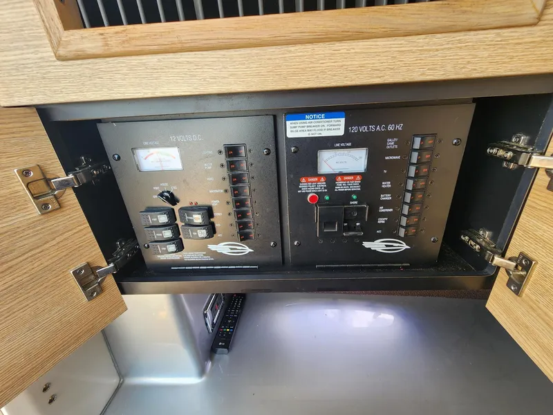 Slide: The Image of Electrical control panel inside 2012 Chaparral 327 SSX boat, featuring switches and voltage meters. - 7