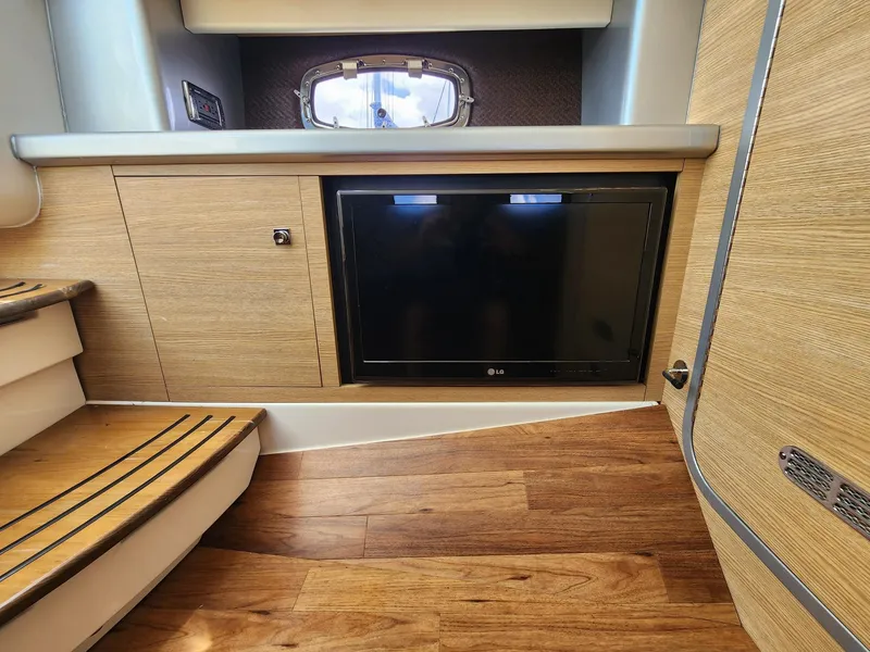 Slide: The Image of 2012 Chaparral 327 SSX interior with wood flooring, built-in TV, and modern cabinetry. - 9