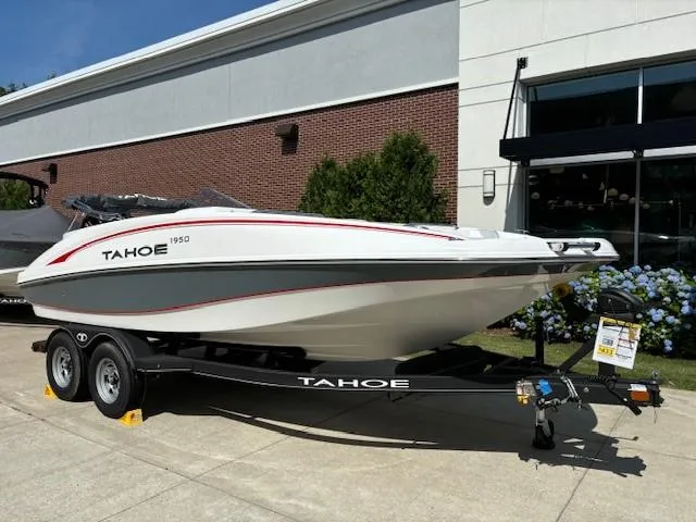 Slide: The Image of 2024 Tahoe 1950 boat on a trailer outside a building. - 1
