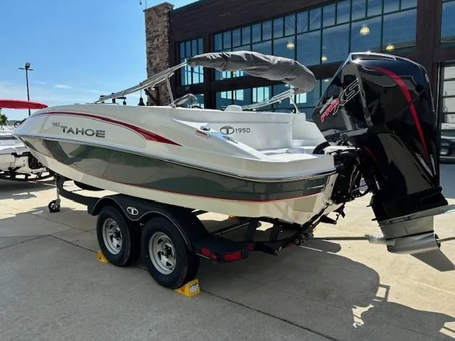 Slide: The Image of 2024 Tahoe 1950 boat on trailer with outboard motor, parked outdoors. - 3