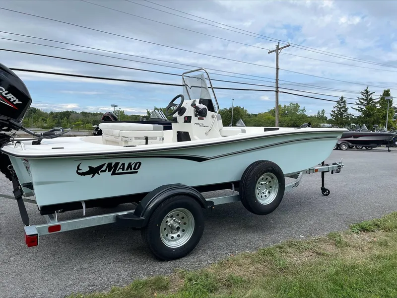 Slide: The Image of 2024 Mako Pro Skiff 15 CC boat on trailer, parked outdoors. - 1