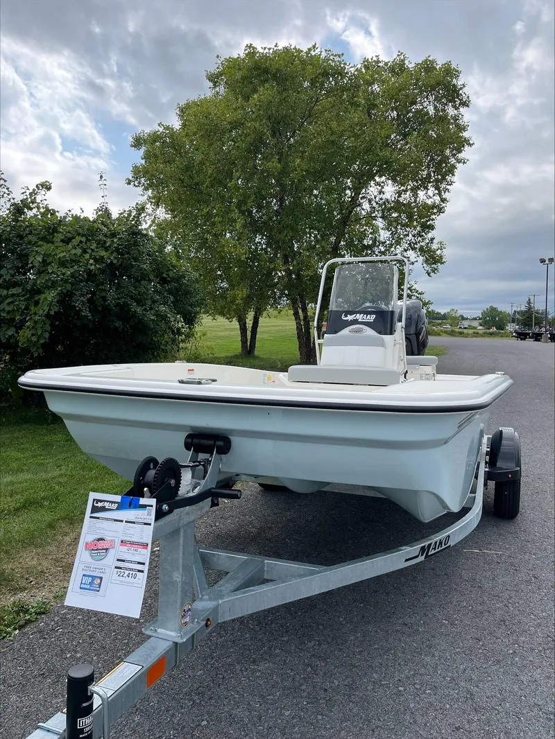 Slide: The Image of 2024 Mako Pro Skiff 15 CC boat on trailer, parked outdoors. - 2
