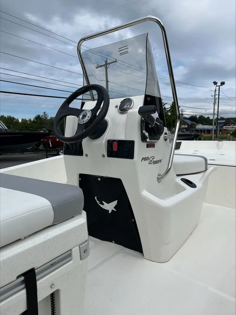 Slide: The Image of 2024 Mako Pro Skiff 15 CC boat with steering console and seating. - 3