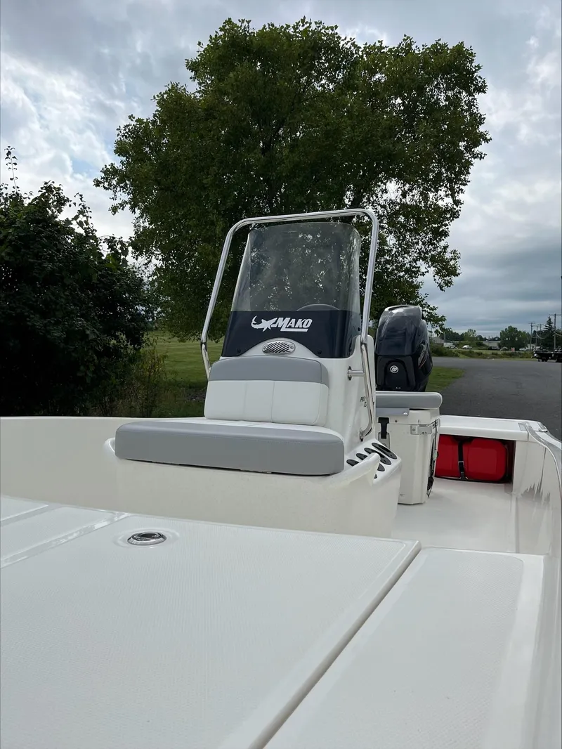 Slide: The Image of 2024 Mako Pro Skiff 15 CC boat with console and seating, parked outdoors. - 4
