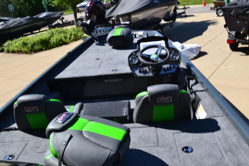 Slide: The Image of 2024 Ranger RT188 boat interior with green and black seats, steering console, and spacious deck. - 2