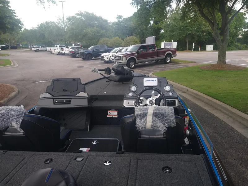 Slide: The Image of 2024 Nitro Z19 boat interior with steering wheel and seats in parking lot. - 2