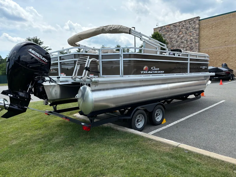 Slide: The Image of 2024 Sun Tracker SportFish 22 DLX pontoon boat on a trailer. - 2