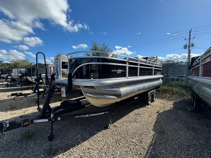 Slide: The Image of 2024 Sun Tracker SportFish 20 DLX pontoon boat on trailer, parked outdoors. - 0
