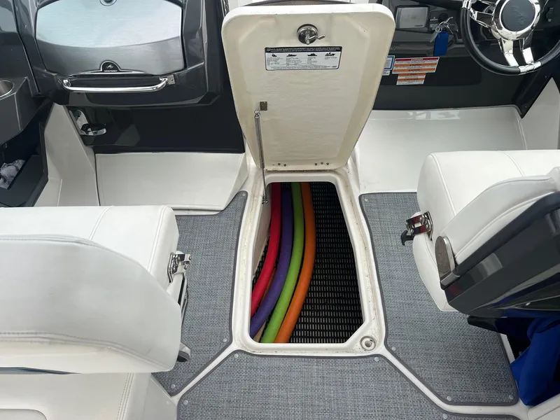 Slide: The Image of 2014 Monterey 288 SS boat interior with open storage compartment and colorful pool noodles. - 10