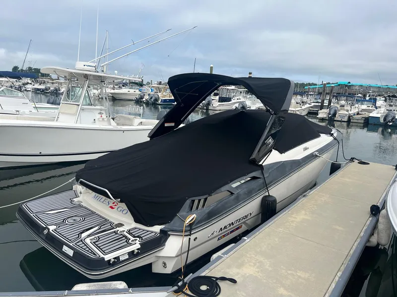 Slide: The Image of 2014 Monterey 288 SS boat docked at a marina with a black cover. - 15